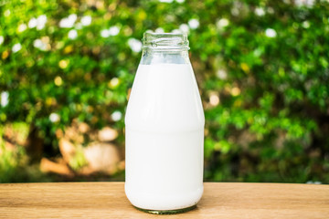 A bottle of milk on wood table.