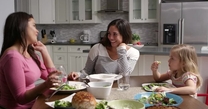 Lesbian couple and daughter having dinner in their kitchen, shot on R3D