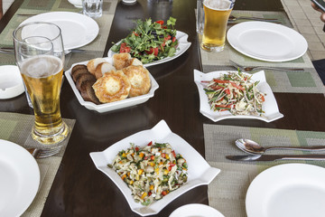 A glass of beer and vegetable salads are a good prelude to dinner.