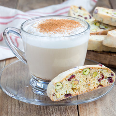 Biscotti with cranberry and pistachio with cup of coffee latte, square format