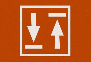 White arrow on orange asphalt floor