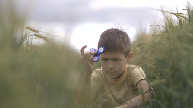 boy playing with a spiner in a wheat field
