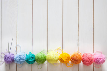 Balls of colored yarn. View from above. All the colors of the rainbow. Sample knit. Crochet.