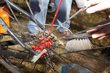 Obraz premium Person cleaning dirty spokes of bicycle