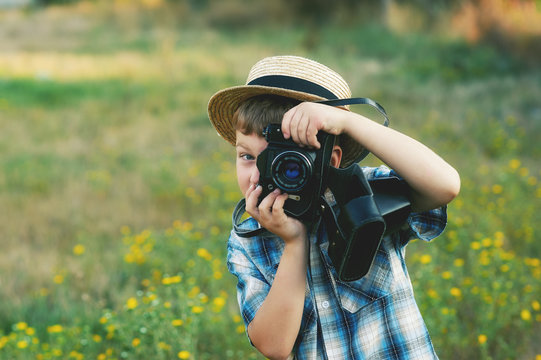 A little boy with an old camera .Young cheerful photographer