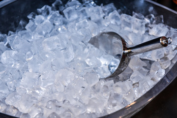 Ice in Ice Bucket with cool, iced scoop preparation of ice in a bar for event party