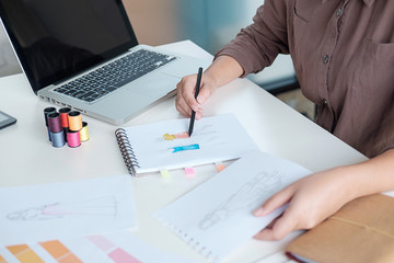  attractive young woman fashion designer standing and working in studio