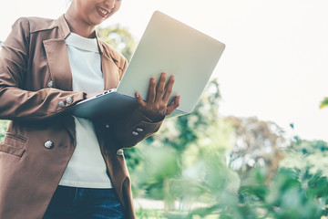 Young  business female using laptop  while she is relaxing in coffee shop in the fresh air