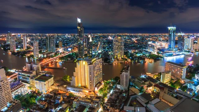 Aerial Bangkok Night Cityscape Riverside Chao Phraya River Of Thailand 4K Time Lapse (pan right)