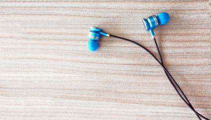 Earphone or earphones on wooden background.the white earphones for using digital music or smart phone | earbuds isolated. Top view.