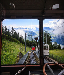 Begin your journey and discover switzerland with famous traditional locomotive swiss railway train, wander through beautiful swiss alpine scenery toward top of majestic mountain peaks in Switzerland,