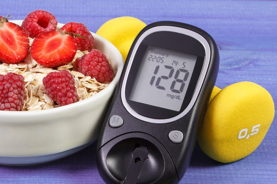Glucometer, oat flakes with fruits and dumbbells, concept of diabetes and healthy lifestyle