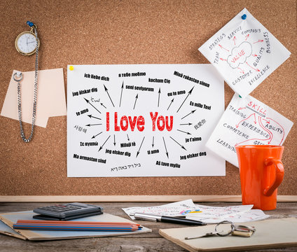 I love you Concept. Chart with text in different languages. Communication and love background. Wooden office desk with a big mess.