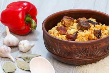 Rice pilaf in clay bowl with meat and vegetables