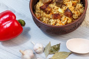 Rice pilaf in clay bowl with meat and vegetables