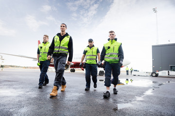 Low Angle View Of Workers Walking On Runway