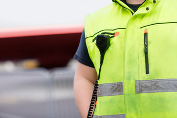 Worker With Microphone Attached On Reflective Jacket At Airport © Tyler Olson