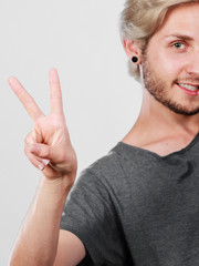 Content young man showing victory sign