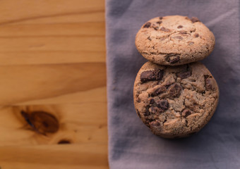 Stack of chocolate chips on wooden background 