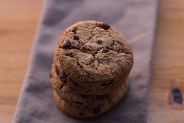 Stack of chocolate chips cookies on brown background
