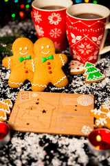 Christmas card - gingerbread man gingerbread, christmas decor, snow, candles, cup with cocoa, tea or coffee and Christmas light