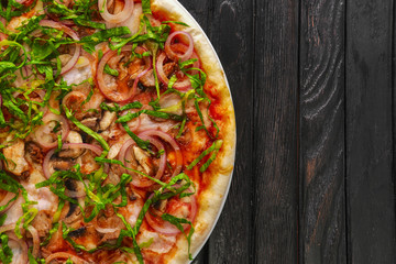 Top view of tasty pizza with sausage and shallot on dark wooden background