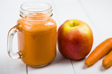 Apple-carrot juice on a wooden table.