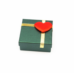 Christmas present box with gold ribbon and red heart on cover isolated on white background.