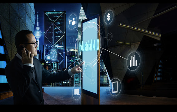 Businessman touching "Industrial 4.0" word on screen of digital booth with fintech infographic. Hi-tech business concept .
