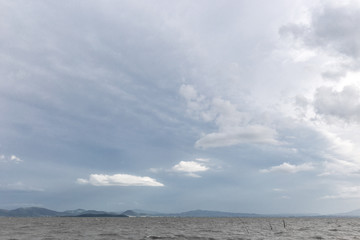 Fototapeta premium Lake on a moody day with very white clouds over an island