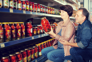 Portrait of an elderly couple buying a salted tomatoes at the gr