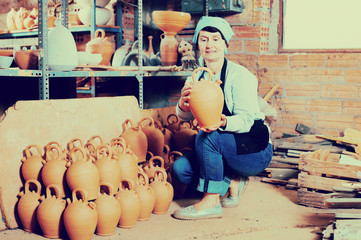 Mature master among the pottery at the workshop