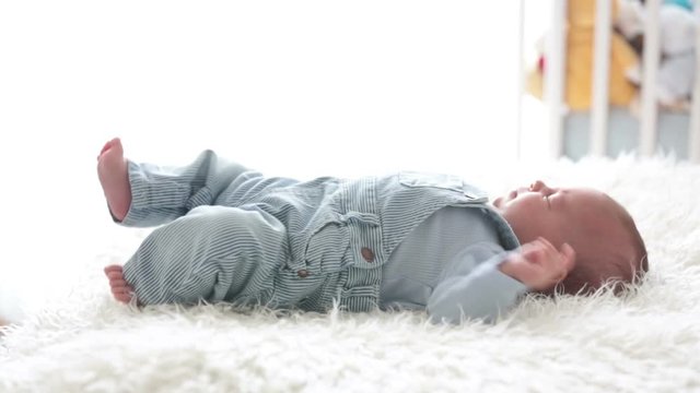 Cute little newborn baby, looking into the camera, happily smiling