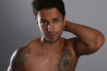 Sexy male posing shirtless on a gray background 