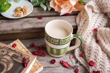 Cup of coffee and book on the wooden bench 