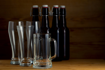 Beer glasses and beer bottles on a wooden background