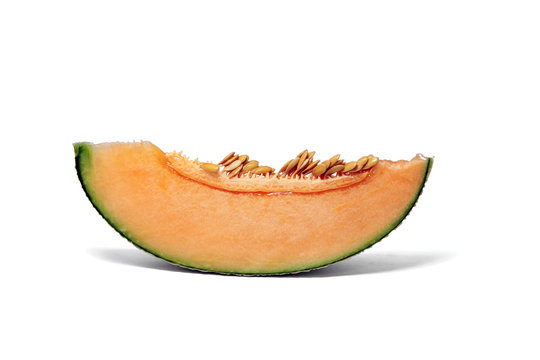 Pieces of orange Melon or cantaloupe fruit show flesh and seeds on white background.