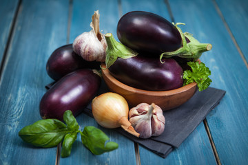 Fresh healthy eggplants on dark wooden background.