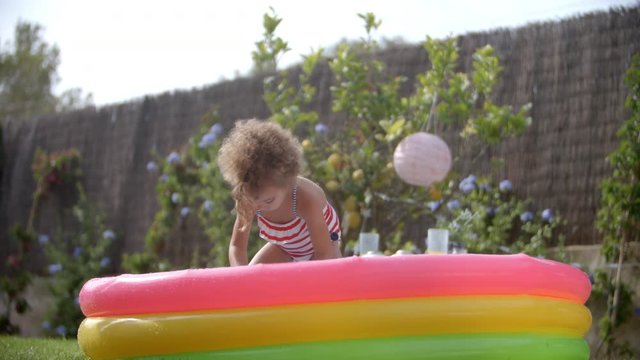 Girl Having Fun In Garden Paddling Pool