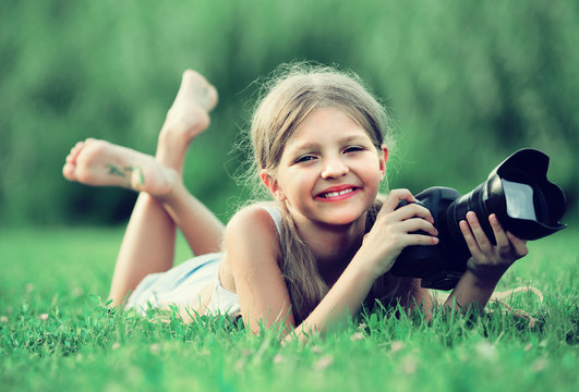 girl lying in park with camera