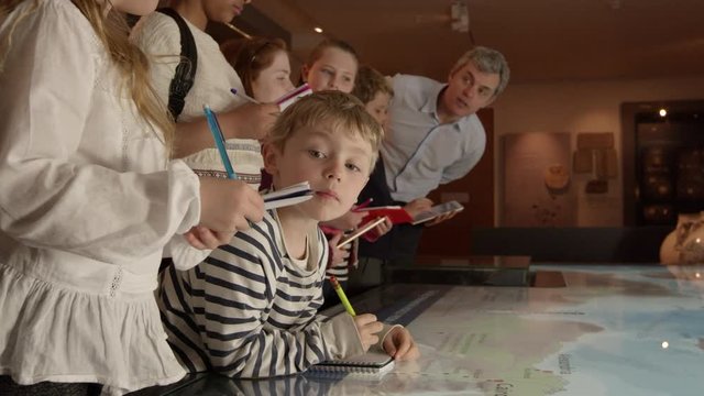 Pupils On School Trip To Museum Looking At Map Shot On R3D