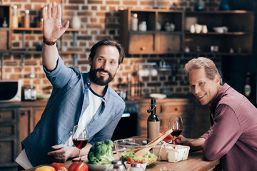 men drinking wine in kitchen