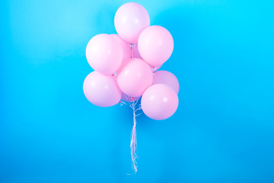 Pink birthday balloons on blue (cyan) background with copy space for text. Pink pastel party balloons, free space. Love, happiness, valentine, wedding honeymoon concept. Happy holiday flying balloons