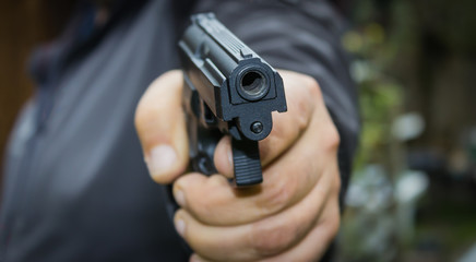 man with a gun, gun muzzle in focus
