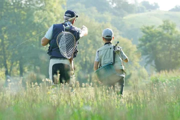 Zelfklevend Fotobehang  Daddy and son walking in field, fishing day © goodluz