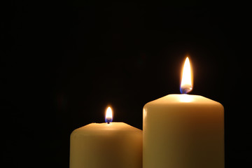 Burning candles over black background