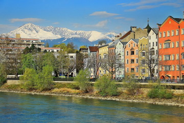 Fototapeta na wymiar Beautiful building by the river, mountain and the blue sky in Innsbruck, Austria. Morning in spring time.