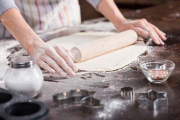 Fototapeta na wymiar woman rolling raw dough