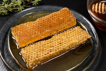Honey and honeycomb on black dish