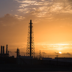 Silhouette oil refinery at sunrise. Oil factory, petrochemical plant tower, gas flare, smoke stacks...